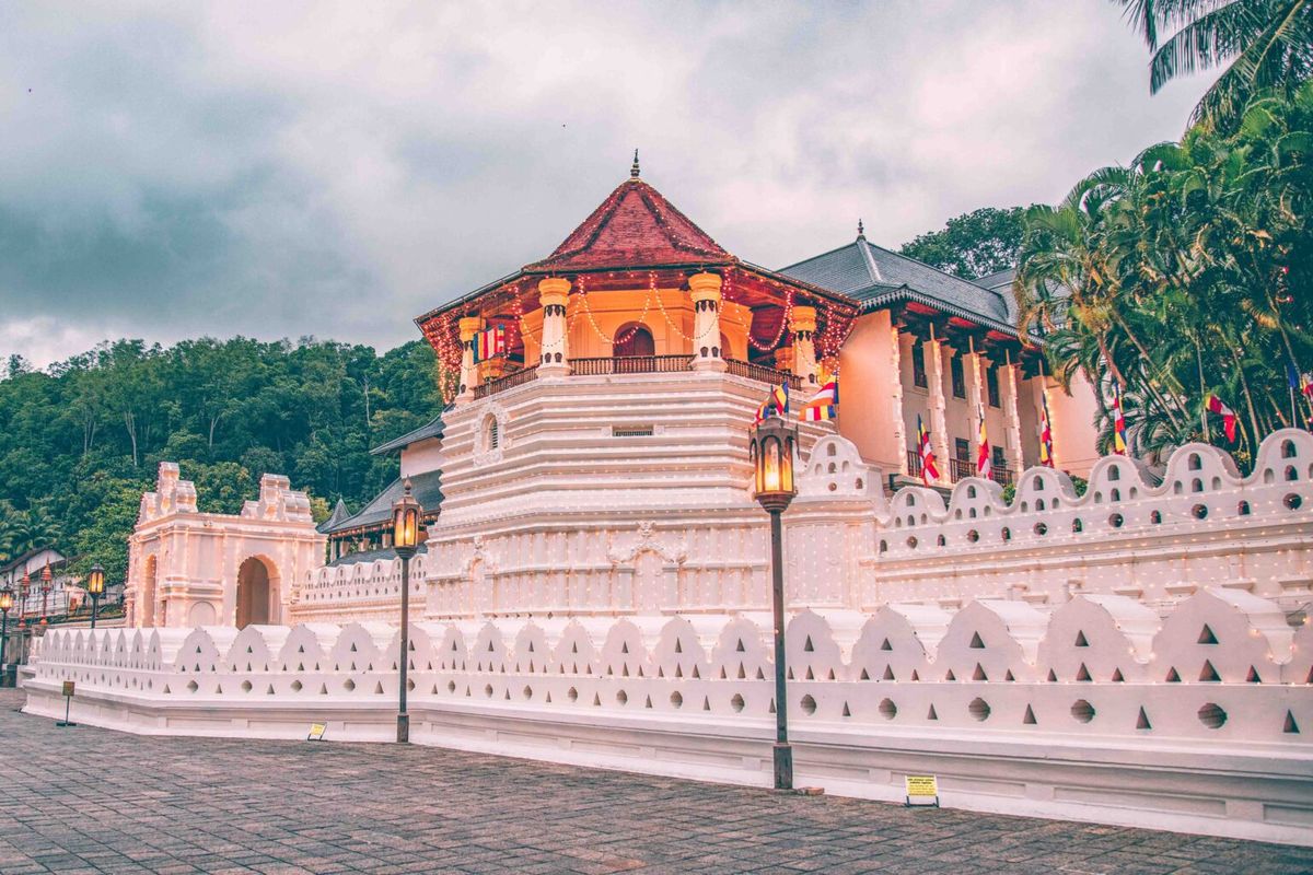 Temple of the Sacred Tooth Relic in Kandy glowing at dusk